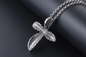Macro view of stainless steel cross pendant with detailed feather texture and sturdy O-chain