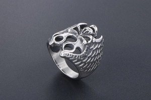 Close-up of gothic stainless steel ring with carved wings and small skull details