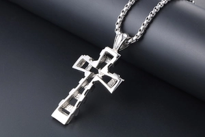 Macro shot of silver titanium steel cross pendant with hollow mechanical design and box chain