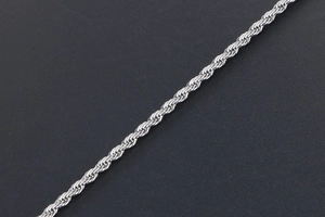 Macro detail of polished stainless steel rope chain showing dense woven texture