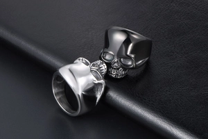 Detailed view of silver and black skull rings on premium black textured leather