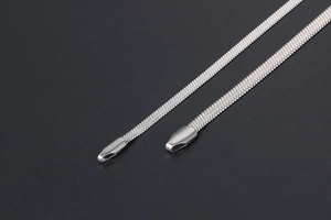 Macro view of silver flat snake bone chain showing metallic texture and polished clasp