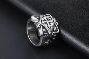 Close-up of gothic vintage stainless steel ring with embossed cross on black leather
