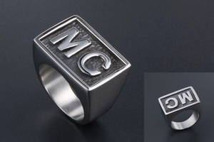 Macro view of wide titanium steel ring with MC relief engraving and grainy texture