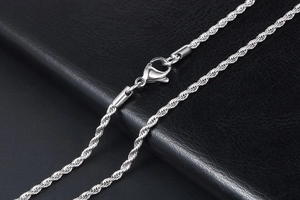 Close-up of a silver stainless steel rope chain necklace with a lobster clasp on leather