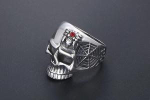 Macro view of vintage skull ring featuring a red rhinestone spider and web details