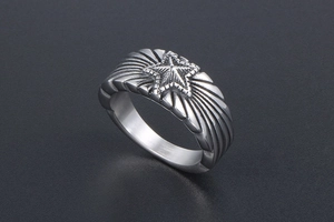 Gros plan d'une bague rétro en acier titane avec étoile et textures de lignes radiales