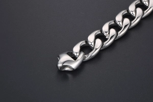Detailed macro view of high-polished stainless steel Cuban link chain with secure clasp