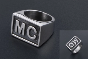 Detail view of the polished silver biker ring featuring a 3D embossed MC letter design