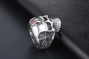 Macro detail of retro skull ring with red gemstone inlay and spider web engraving