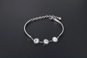 Detailed close-up of a silver fashion bracelet with three round crystals and adjustable chain