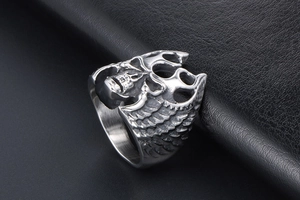 Macro shot of retro stainless steel skull ring with embossed wings on black leather
