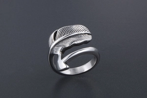 Macro view of vintage silver feather ring with detailed texture on smooth titanium steel