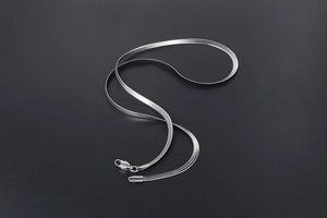 Close-up of polished silver herringbone chain with secure lobster clasp on grey background