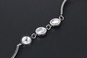Close-up of titanium steel bracelet with three round cut crystals in bezel setting