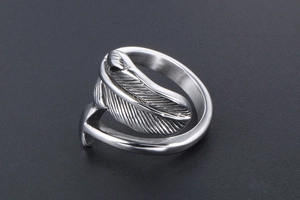 Macro shot of silver titanium steel ring with detailed feather texture and open band
