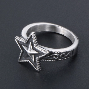 Detail of vintage star engraved ring with matte silver finish and tribal patterns