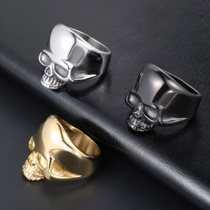 Vintage punk skull rings in silver, black, and gold steel on a black leather texture
