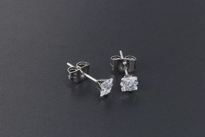 Macro shot of minimalist silver titanium steel stud earrings with square-cut clear zircons