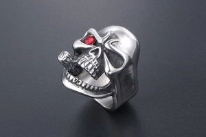 Macro close-up of a silver punk skull ring for men with a red gemstone eye detail