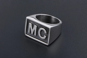 Macro shot of silver signet ring with MC letter engraving and pear-skin texture