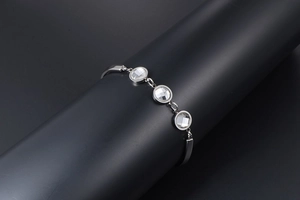 Macro detail of silver titanium bracelet featuring three clear round zircon stones