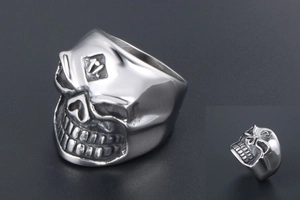 Close-up detail of silver skull ring with engraved 1% symbol in gothic punk style