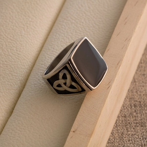 Macro shot of vintage titanium steel ring with black resin inlay and Celtic knot details