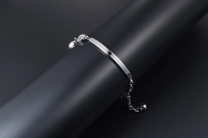 Detail of silver titanium bracelet featuring curved metal bar and sparkling crystal accents