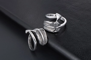 Detailed view of silver feather arrow ring with clear texture on black leather