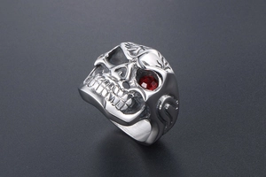 Macro detail of gothic skull ring with polished red gem eye in vintage steel