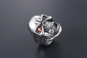 Detail view of gothic skull ring with red rhinestone eye inlay on polished steel