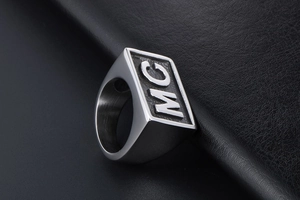 Detailed macro shot of the polished silver stainless steel signet ring with MC lettering
