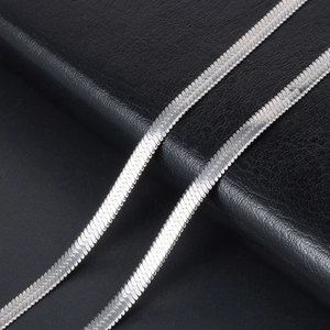Sleek silver flat snake chain necklace for men and women on a black leather background