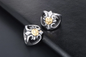 Close-up of gothic stainless steel ring with gold eagle emblem on black leather