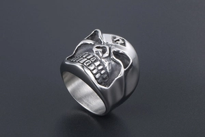 Macro shot of silver vintage skull ring featuring detailed rock punk engraved patterns