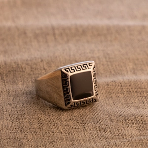 Close-up of vintage men's stainless steel ring with black enamel and Greek fret pattern