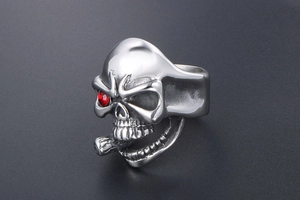 Macro view of punk skull ring with red rhinestone eye and detailed cigar in silver finish