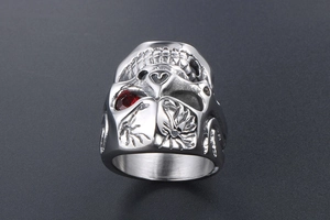 Detailed macro view of gothic skull ring with red eye gemstone and stainless steel texture
