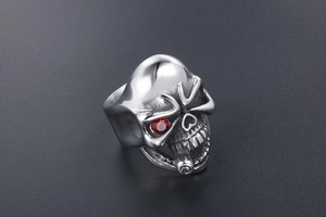Macro detail of gothic skull ring with red zircon eye inlay and oxidized steel finish