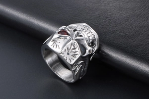Macro view of punk skull ring with red eye stones and detailed flame engraving