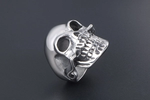 Vue latérale macro d'une bague tête de mort punk en acier poli aux détails gothiques