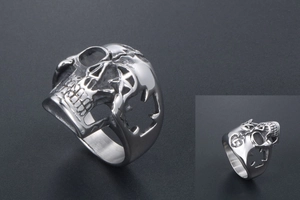 Macro view showing hollowed star and cross details on the silver skull ring band