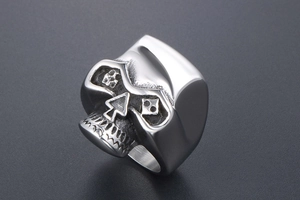 Vue macro d'une bague crâne pour homme avec nez en pique et détails de cartes à jouer