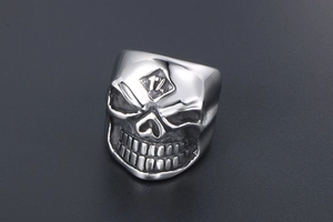 Macro shot of silver gothic skull ring with embossed forehead design and distressed finish