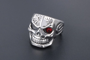 Macro detail of gothic skull ring in stainless steel with a striking red zircon eye