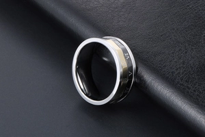 Détail macro de la bague tricolore en acier inoxydable avec chiffres romains gravés