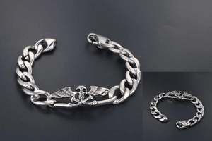 Détail d'un crâne rétro avec ailes sur un bracelet gourmette en acier argenté de style punk