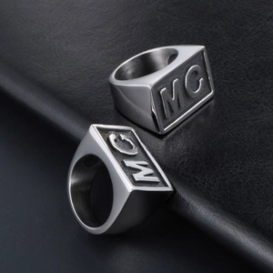 Mens brushed stainless steel ring with MC letter relief on black leather background