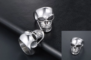 Detailed views of a polished stainless steel punk skull ring against dark leather background